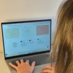 Photo de OhDrey de dos en train de travailler sur un ordinateur, illustrant un contact professionnel et personnalisé.