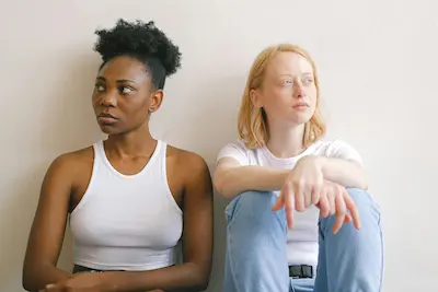 Deux jeunes femmes assises côte à côte, tournées l’une de l’autre, symbolisant une relation conflictuelle ou toxique